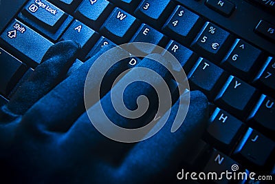 Black glove on computer keyboard Stock Photo