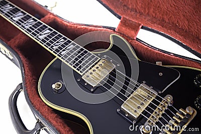 Black and gold electric guitar in red fur-lined case Stock Photo