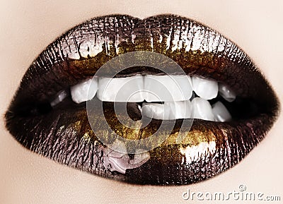 Black gold lips biting Stock Photo