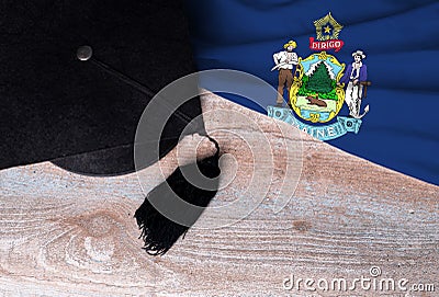 Black graduation hat on Maine flag, education concept, top view Stock Photo