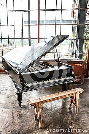 Black Grand Piano and stool in a well lit room Stock Photo