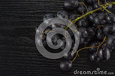 Fresh raw black grape on black wood Stock Photo