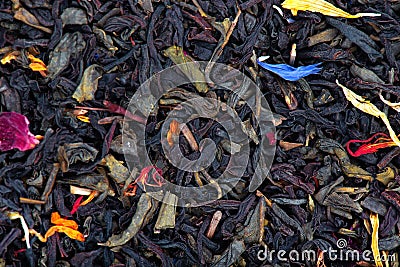 Black and green Ceylon tea with dry flowers - calendula, rose and cornflower petals, background. Stock Photo