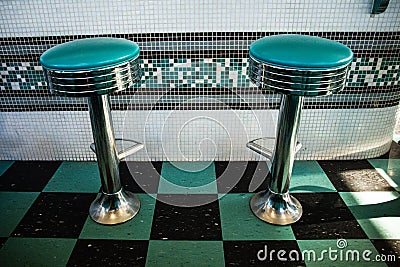 Black and green: tyipical american diner vintage interiors with stools and checkered floor Stock Photo