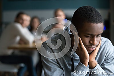 Black guy sit alone in cafe suffering from racial discrimination Stock Photo