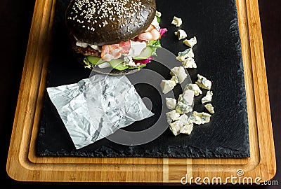 Black hamburger made from beef, with dor-blu. Place for recording. Stock Photo