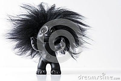 A black happy toy troll with big har and arms wide open isolated on white studio background with copy space for text Editorial Stock Photo
