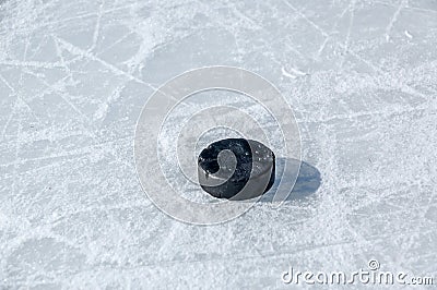 Black hockey puck on ice rink Stock Photo