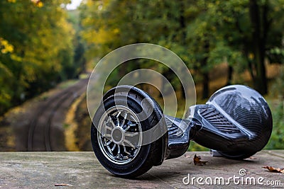 Black hoverboard against the background of railroad rails Stock Photo