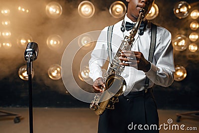 Black jazz performer plays the saxophone on stage Stock Photo