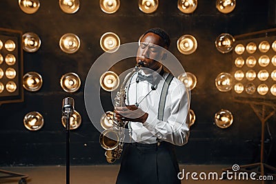 Black jazz performer plays the saxophone on stage Stock Photo