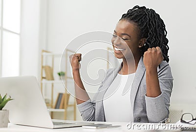 Black Lady Celebrating Business Success Sitting At Laptop In Office Stock Photo