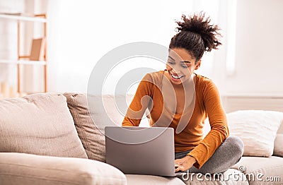 Black Lady Using Laptop Sitting On Sofa At Home Stock Photo