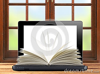 Black laptop and openned book wooden table over window Stock Photo