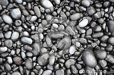 Black lava pebbles on beach Stock Photo