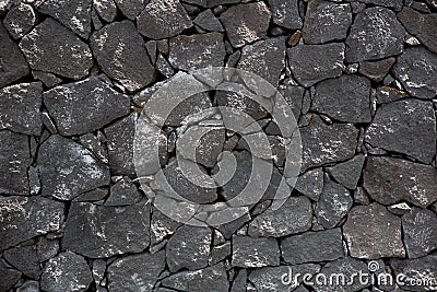 Black lava stone volcanic masonry wall Stock Photo