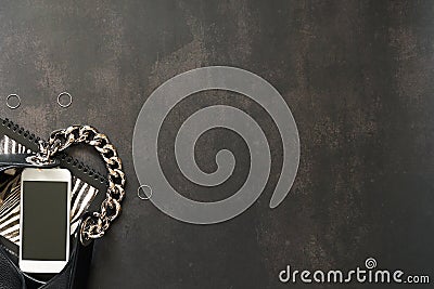 Black leather bag with chain, white phone, zebra print on a black background Stock Photo