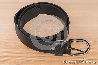 Black leather belt with semicircular frame buckle on light surface Stock Photo