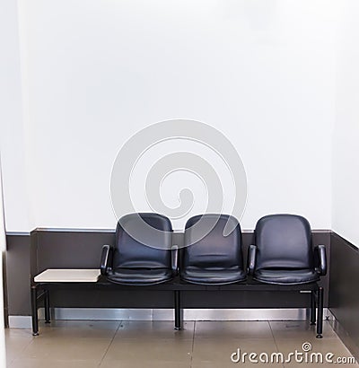 Black leather bench seat row on white wall background in waiting area. Architectural Home or Office Interior, House Furniture, Stock Photo