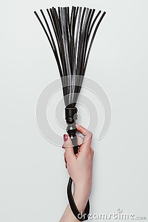 Black leather whip in female hand Stock Photo