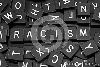 Black letter tiles spelling the word & x22;racism& x22; Stock Photo