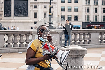 Black Lives Matter protest during lockdown coronavirus pandemic. Lady with megaphone Editorial Stock Photo