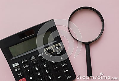 Top view and flat lay black magnifying glass and calculator on pink pastel background.Business and finanse concept Stock Photo