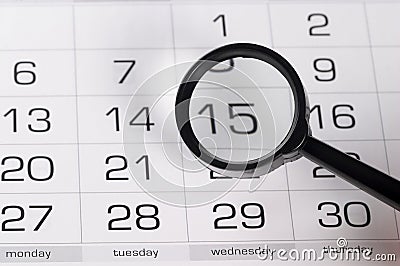 Black magnifying glass over calendar Stock Photo