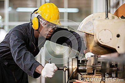 Black male african american workers wear sound proof headphones and yellow helmet working. Stock Photo