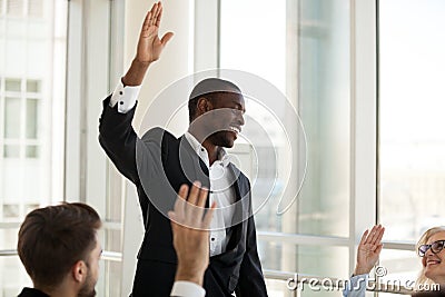 Black male coach hold teambuilding activity with workers raising Stock Photo