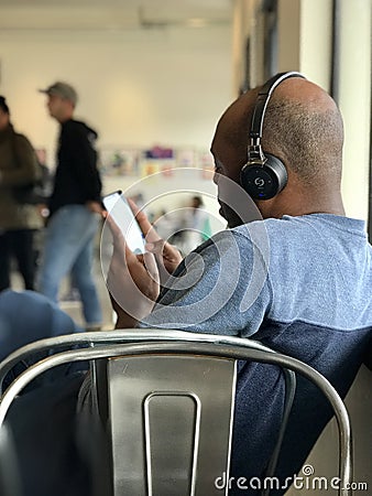 African American Male with Headphones and Cell Phone Editorial Stock Photo