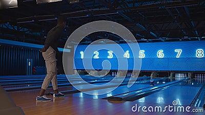 A Black Man Bowling Man Throws a Ball in Slow Motion and Knocks Down  Skittles. Play Bowling Stock Footage - Video of rolling, success: 234509688