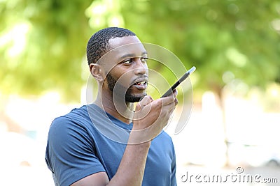 Black man dictating audio message on smart phone Stock Photo
