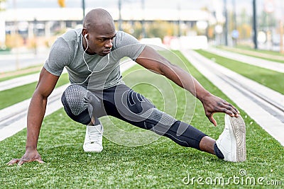 Black man doing stretching before running in urban background Stock Photo