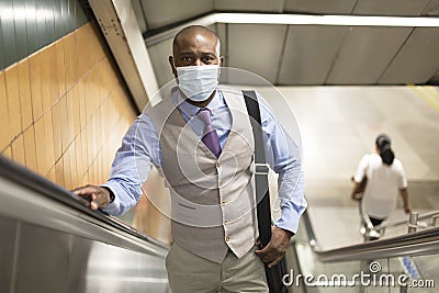 Black man with medical mask climbing subway stairs Stock Photo