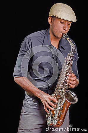 Black man playing the saxophone, feeling the music with white hat Stock Photo