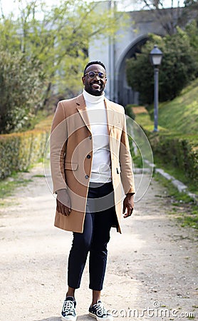 Black man walking with glasses, well dressed. Posing. In a park Stock Photo