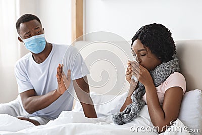 Black man wearing face mask while his wife is sick Stock Photo