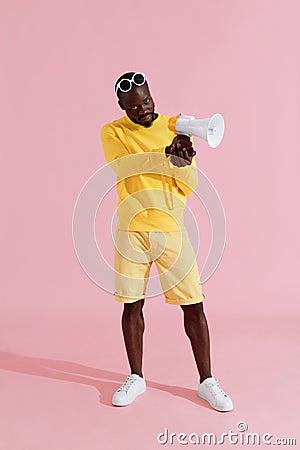 Black man in yellow fashion clothes with speaker megaphone Stock Photo