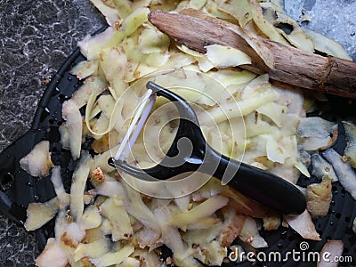 Plastic potato peeler with fresh white potato peelings Stock Photo