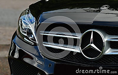 Black Mercedes-Benz AMG sport C-class 220d car, closeup front view of an emblem Editorial Stock Photo