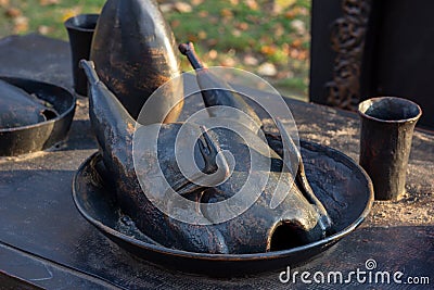 The black metal baked chiken on a plate as a part of statue in the city street. Editorial Stock Photo