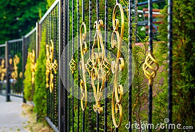 black metal fence with gilded iron elements Stock Photo