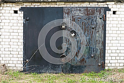 Black metal garage gate with three big locks Stock Photo