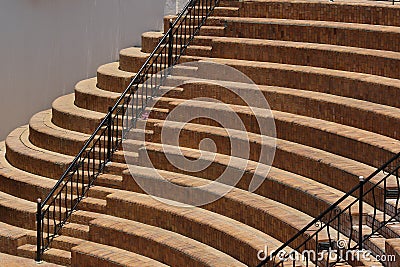 Black metal railings and round, semicircular steps in the amphitheater sector, a fragment of the seats - steps Stock Photo