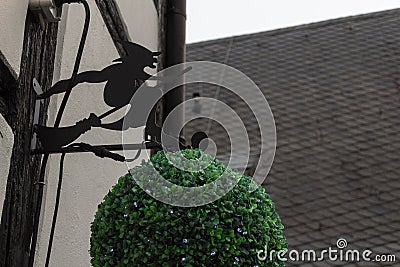 Black metallic witch on broom illustration logo on a building side germany Cartoon Illustration
