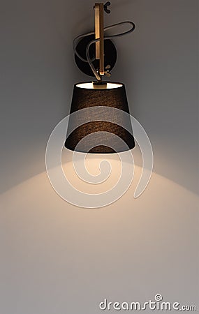 Black modern wall light shines on a dark gray wall. Free space Stock Photo