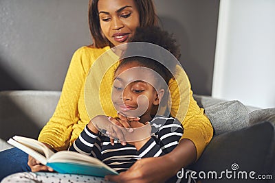 Black mom and daughter reading a book Stock Photo