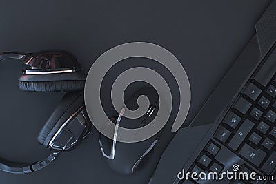 Black mouse, the keyboard, the headphones are isolated on a dark background, the top view Stock Photo
