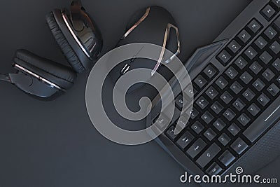 Black mouse, the keyboard, the headphones are isolated on a dark background, the top view. Flat lay gamer background Stock Photo